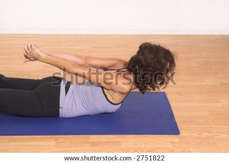 woman doing yoga on blue mat in studio