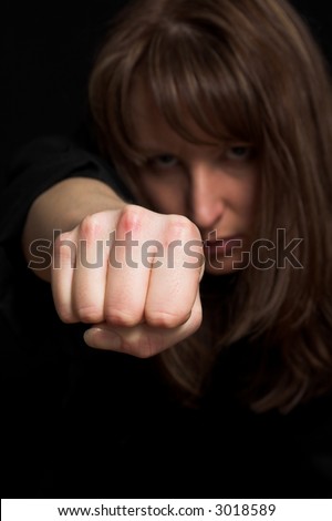 woman close up portrait pointing fist on black backdrop