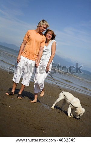 young couple on the beach with dog in vancouver