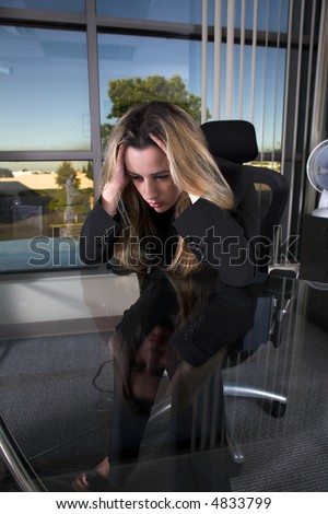 business woman indoor shot sitting depressed at her desk