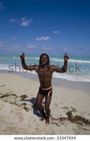 black man dancing on the beach back in the blue sea over blue sky
