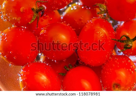 Cherry tomatoes splashing into the water