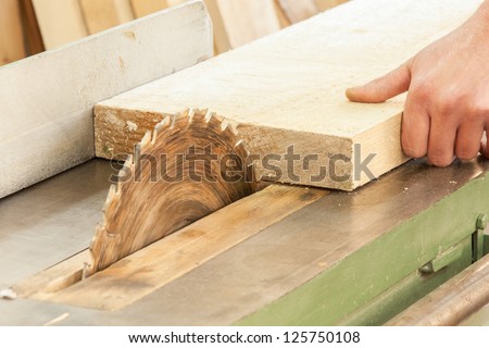 A carpenter  works on woodworking the machine tool. Carpenter working on woodworking machines in carpentry shop.