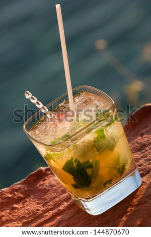 Mojito  cocktail . Cocktail against sea. Outdoor composition during sunset lights. Shallow DoF