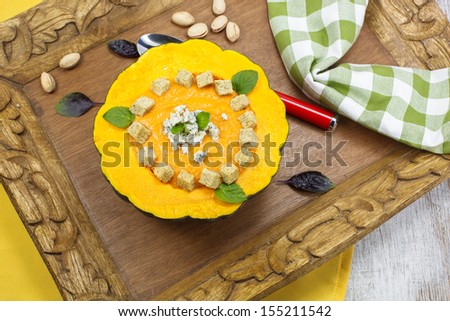 Pumpkin soup. Delicious traditional  pumpkin soup with cheese, seeds and croutons. Pumpkin soup served in pumpkin.  Above view