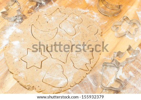 Gingerbread cookies. Making gingerbread cookies. Christmas baking background dough, cookie cutters, spices and nuts. Viewed from above