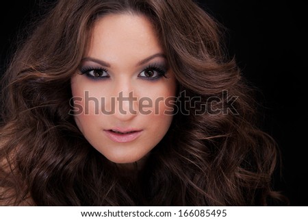 Beautiful Brunette Girl. Beauty Girl\'s Face.Curly hair. Close up portrait in dark tones