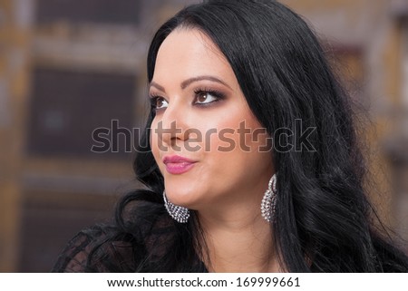 Beautiful  elegant woman sitting daydreaming or thinking,  looking up and smiling.