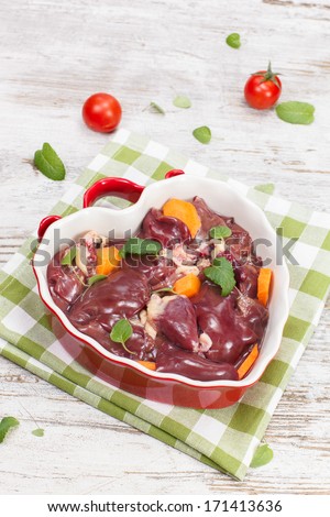 Raw liver.  Chicken liver in heart shaped bowl. Ready to cook. High angle view. Copy space
