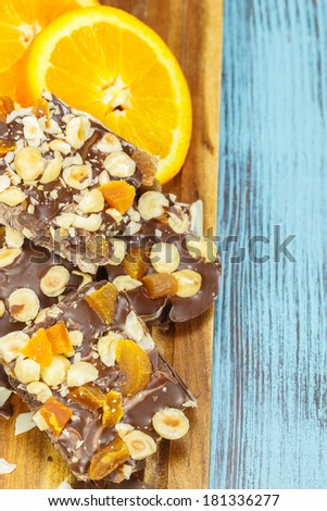 Chocolate and Orange. Homemade dark and white  chocolate bar with orange slice and nuts. Macro, selective focus