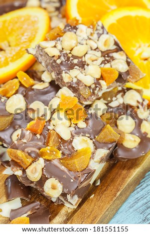 Chocolate and Orange. Homemade dark and white  chocolate bar with orange slices and nuts. Macro, selective focus