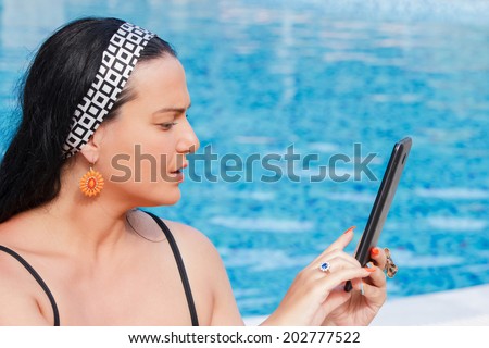 Young woman with touch pad on vacation.  Working on vacation concept