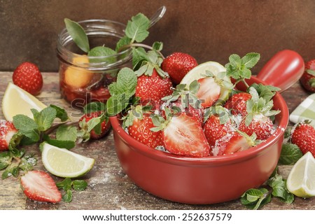 Strawberry jam. Making strawberry jam,  stirring strawberries and sugar and fresh fruits on a background of rustic  wood. Macro, close up