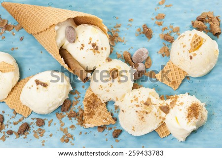 Vanilla Ice Cream, cone and cone pieces scattered.  Macro photograph with shallow depth of field.
