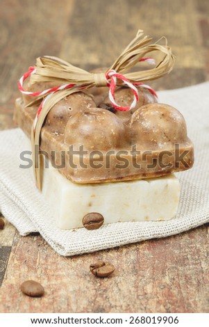 Coffee soap. Organic handmade coffee soap and coffee beans on wood table with linen napkin. Macro photograph with  shallow depth of field