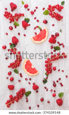 Fresh whole and sliced red fruits. Collection of fresh whole and sliced red fruits on white rustic background. Still life pattern background. Overhead view