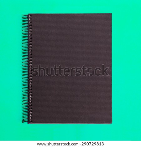 Black notebook front cover isolated on colored background