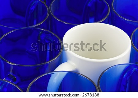 White coffee mug amongst blue glass mugs - horizontal format