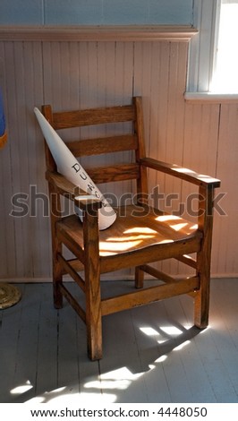 Dunce\'s Chair - old schoolhouse dunce cap chair in dramatic lighting - dust and grit cover everything