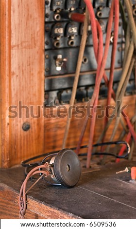 Vintage Telephone Operator\'s Headphones rest on telephone operator\'s desk - focus on headphone