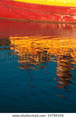 Reflections of tugboat on harbor waters