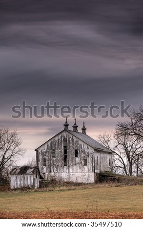 Hard Times on the Farm - old barn in decline under gloomy skies - copy space to top