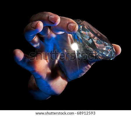 Diamond in the Rough - Dirty male hand hold diamond against black background - blue lit from underside, natural flare