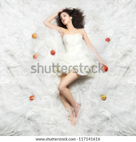 Beautiful Caucasian girl sleeping after eating the forbidden fruit. Photographed from above