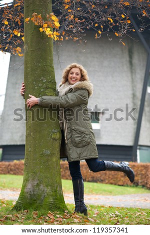 A beautiful middle age woman tree hugging in Europe