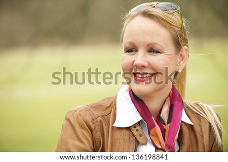 Close up portrait of a beautiful older woman smiling and enjoying life outdoors