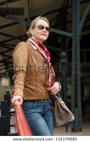 Portrait of an attractive middle aged woman with sunglasses and bag