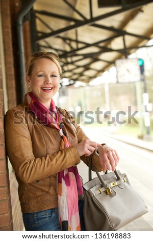 Portrait of an attractive older woman smiling and pointing to her watch