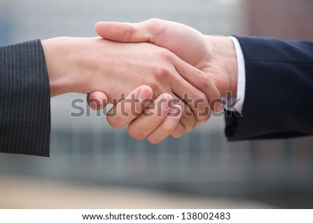Businessman and business woman handshake close up