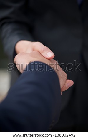 Close up business man and business woman handshake