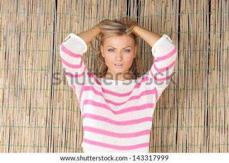 Horizontal portrait of a beautiful young woman with hands in hair