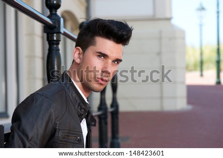 Closeup portrait of a handsome young man in black leather jacket