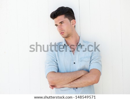Closeup portrait of an attractive male with arms crossed on white background and looking away