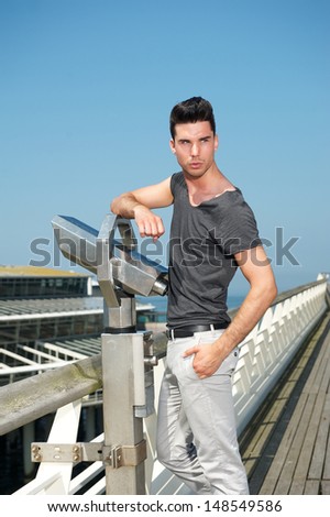 Portrait of a handsome young man standing on pier