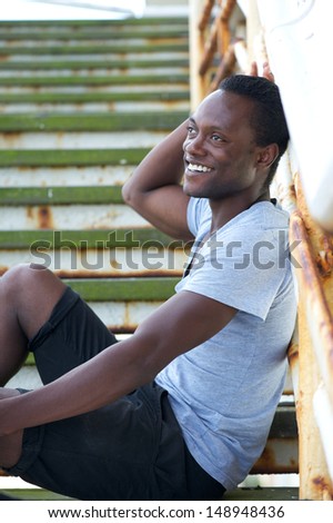 Portrait of an attractive black male sitting outdoors and smiling