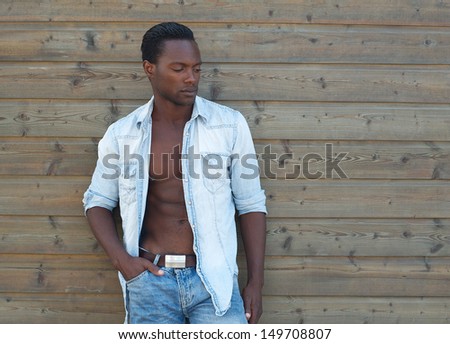 Portrait of a handsome black man standing outdoors with open shirt