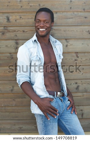 Portrait of a handsome young man smiling outdoors with open shirt
