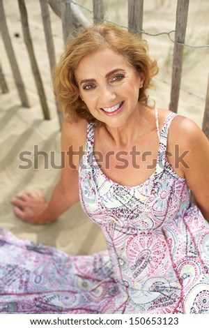 Closeup portrait of a cheerful middle aged woman smiling at the beach