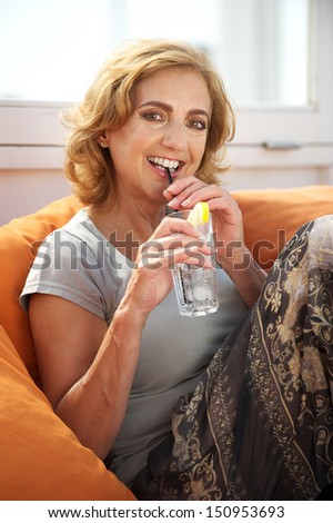 Portrait of an attractive older woman enjoying a drink at restaurant