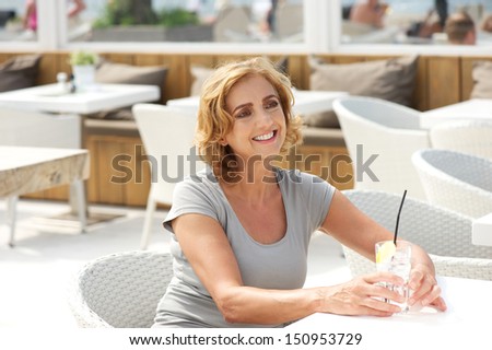 Closeup portrait of a woman smiling in restaurant with glass of water