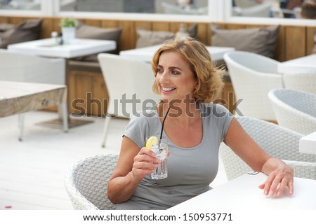 Closeup portrait of an older lady relaxing with a drink of water at restaurant