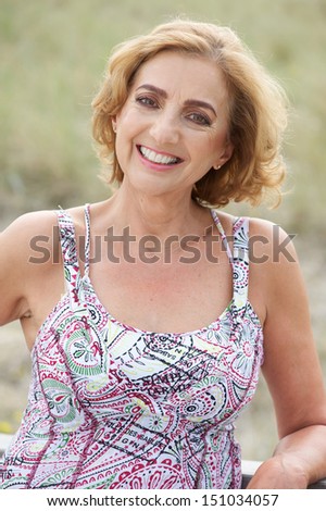 Closeup portrait of a beautiful older woman smiling outdoors