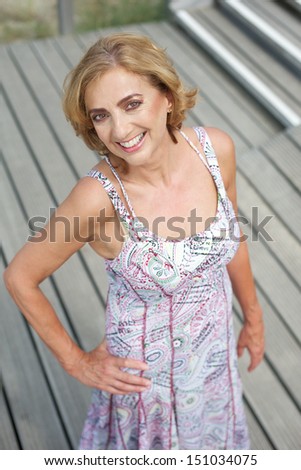 Portrait of a beautiful older woman posing outdoors with a smile