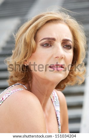 Portrait of an older woman standing alone outdoors