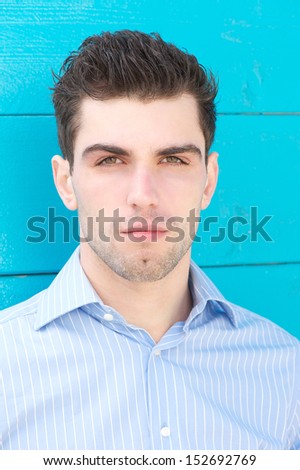 Closeup portrait of an attractive male fashion model on blue background