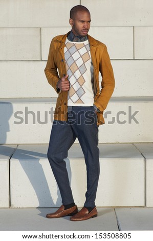 Full length portrait of an attractive male fashion model standing outdoors
